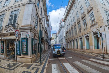 LISBON, PORTUGAL - 8 Nisan 2024: Tuk-Tuk adlı komik elektrikli araba, turistler için şehir sokaklarında kullanılan klasik bir arabayı simgeliyor. R. Augusta ile R. do Comercio kavşağı..