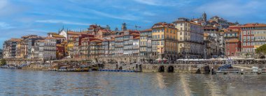 PORTO, PORTUGAL - 11 Nisan 2024: Douro nehri üzerindeki eski kasaba iskelesi mimarisinde eski çok renkli evler ve geleneksel cephelerle panoramik manzara. Porto Ribeira, Cais da Ribeira boyunca..