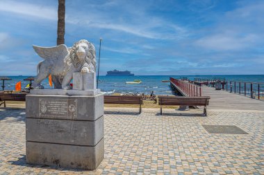 LARNACA, CYPRUS - JUNE 17, 2024: The Venetian Lion monument at Finikoudes promenade, a statue of the Winged Lion of Venice, known as the Lion of St. Mark. Its a gift from Venice to Larnaca in 2010. clipart