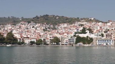 ÜSKOPELOS TOWN, GREECE-AUG. 24, 2023: Geleneksel Yunan Akdeniz mimarisinin denizden görünüşü. Ünlü aşçılar tarafından TV ve restoranlarda kullanılan geleneksel Yunan yemek tariflerinin kaynağı.
