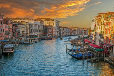 VENICE, İtalya - 18 Mart 2023 Ponte di Rialto 'dan Büyük Kanal manzarası, süslenmiş bir 16. yüzyıl yaya köprüsü. Venedikliler mimari, tekneler, gondol istasyonları, ve akşam çadırlarında teraslar