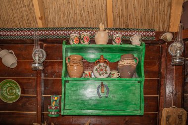 MURIGHIOL, ROMANIA - JULY 20, 2020: Interior with decorated wooden wall of a dining room, with beautiful folk objects typical of the Lipovan ethnic group in Romania. Danube Delta area. clipart