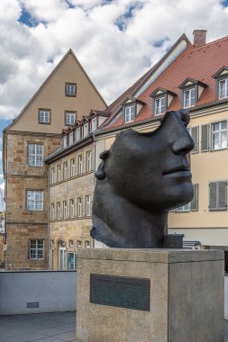 BAMBERG, BAVARIA, GERMANY - 24 Mayıs 2025: Centurione. Yarım yüzlü bronz heykel, Yunan aşk tanrısı Eros 'un hasarlı kafasını tasvir ediyor. Polonya kökenli bir sanatçı olan Igor Mitoraj tarafından yapıldı..