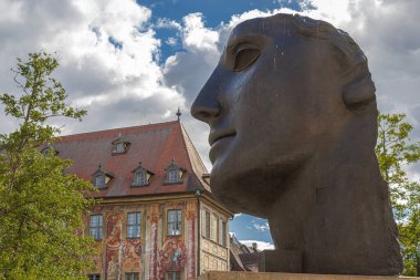 BAMBERG, BAVARIA, GERMANY - 24 Mayıs 2025: Centurione. Yarım yüzlü bronz heykel, Yunan aşk tanrısı Eros 'un hasarlı kafasını tasvir ediyor. Polonya kökenli bir sanatçı olan Igor Mitoraj tarafından yapıldı..