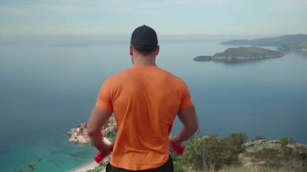 Мужчина Тренирует Плечи Гантелями Природе Красивым Видом Море Высококачественные Кадры — стоковое видео