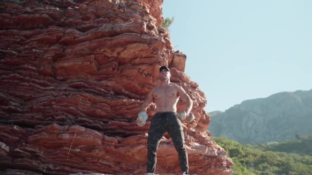 Athlete Beautiful Body Large Muscles Raises His Hands Dumbbells Nature — Videoclip de stoc