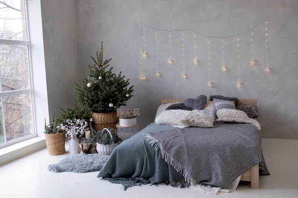 large white bedroom with a large bed, a Christmas tree with gifts and a panoramic window