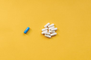 Sarı arka planda bir sürü hap. İlaç ve sağlık hizmetleri kavramı. Vitamin ya da gıda takviyesi. Üst görünüm, kopyalama alanı, yüksek çözünürlüklü ürün.