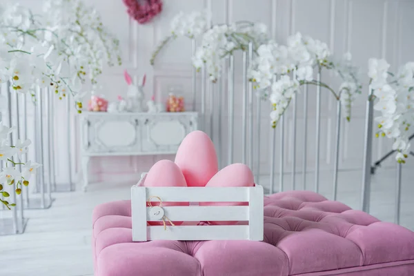 Ahşap şifoniyer, şık paskalya tavşanı heykeli ve yumurtalarla oturma odasının iç tasarımı. Vazoda rengarenk yumurtaları olan minimalist kompozisyon, tavşan heykeli. Paskalya konsepti