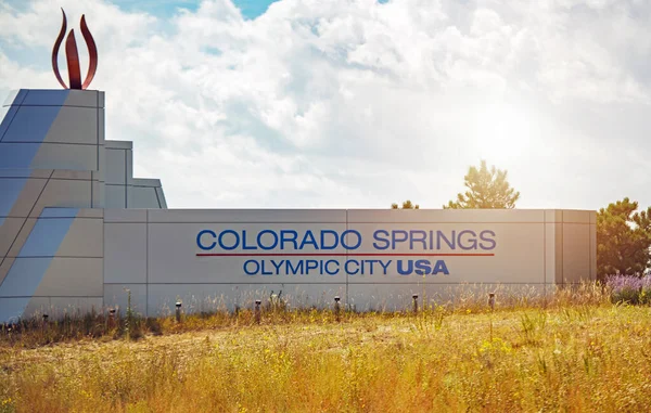 町へようこそアメリカオリンピックシティコロラドスプリングスの標識黄色の草に囲まれています 背景の曇りの空 — ストック写真