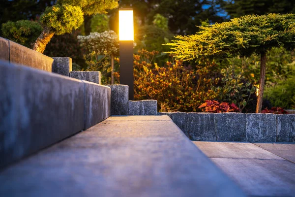 コンクリート裏庭階段に沿って設置された屋外ガーデンライト夕方にそれらを照明します 背景に広がる庭園 — ストック写真