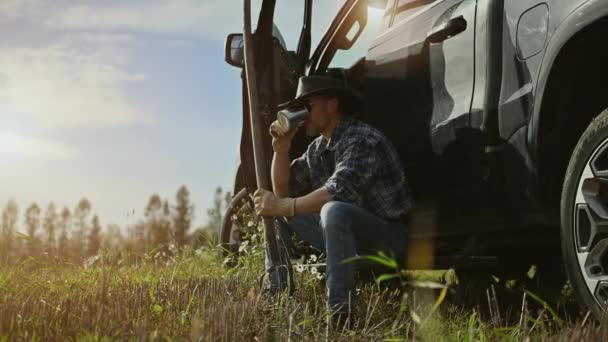 白人カウボーイは農場で午後遅くに新鮮なコーヒーを飲む彼のピックアップトラックの横にある — ストック動画