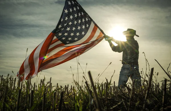 男はアメリカ国旗を振って国の愛を示しています 愛国的なカウボーイ — ストック写真