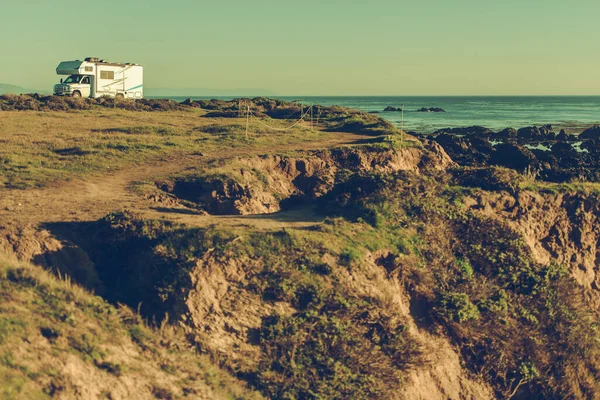 ロンリー キャンパー ヴァンは頑丈な海岸線に駐車した 自動車旅行とライフスタイルのテーマ — ストック写真