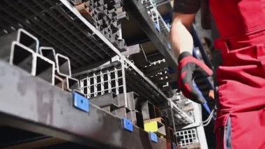 Metalworking Shop Worker Taking Piece of a Metal Square Tube Close Up Photo. Material For a Welding Job.