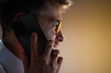 30 'lu yaşlardaki beyaz bir adam işle ilgili telefon görüşmesi yapıyor.