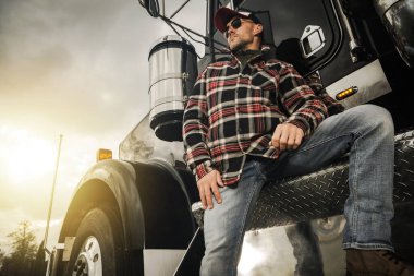 Transportation Industry Theme. Professional Truck Driver Next to His Semi Tractor. clipart