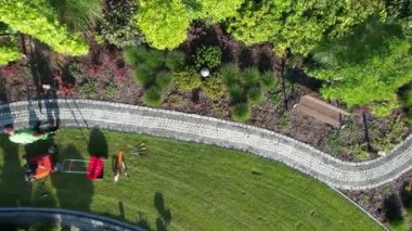Caucasian Garden Worker in His 40s Cleaning Garden Brick Paths Using Air Blower Aerial View
