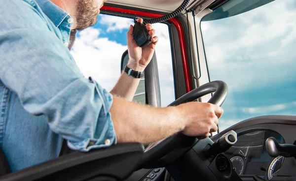 Closeup of Professional Caucasian Truck Driver Communicating via Citizens Band Radio During the Route. Heavy Duty Transportation Theme.