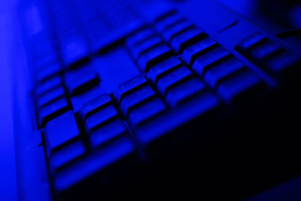 ダークブルーの照明付きデスクトップコンピュータのキーボードを閉じる — ストック写真
