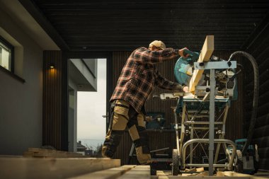 Küçük Mimari Ahşap Projesi. Genel İnşaat İşçisi Güçlü Testere Makinesi ile Ahşap Materyali Boyutuna Kesiyor.