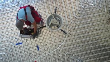 Elinde tüp dilimleyicisi olan beyaz tenli bir işçi. Radyasyon kesen ısıtıcı plastik boru hattı. Isıtma ve Soğutma Endüstrisi Teması.