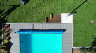 Poolside New Natural Grass Turfs Installation Performed by Professional Landscaper. Residential Swimming Pool Surroundings Design.