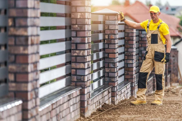 コンクリートレンガとアルミパネルは住宅フェンスを作った 40代の白人建設労働者 — ストック写真