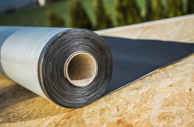 Bir rulo EPDM Ethylene Propylene Diene Terpolymer Material Staying on a Roof. Modern Çatı Malzemeleri.