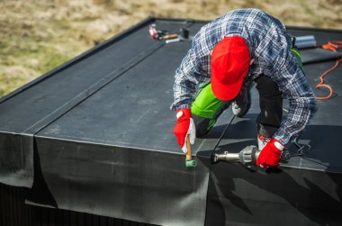 EPDM Membrane Kurulumu Bir Bahçe Barakasının Üzerinde. Profesyonel İşçi Malzeme Parçalarını Hava Esintisi Kullanarak Ekliyor.