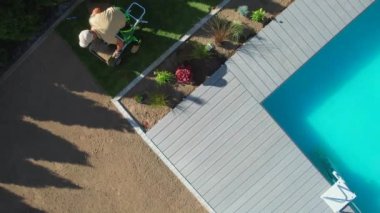 Profesyonel Bahçıvanın Arka Bahçe Havuzu 'nda Çimenlik Çimlerini Çevreleyen Çimenli Çimenlik Çimlerini Çimento Arkasına Getirmesi Üzerine En İyi Görünüm.