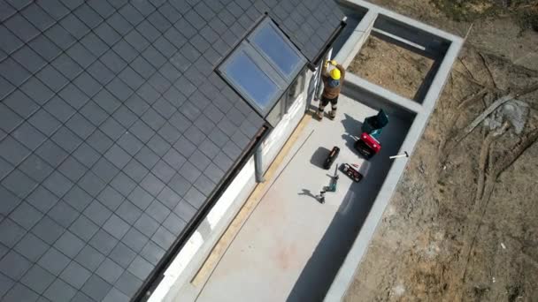 建設現場で働くプロの請負業者のトップビュー雨水排水のための屋根ガターシステムのためのパイプのインストール — ストック動画