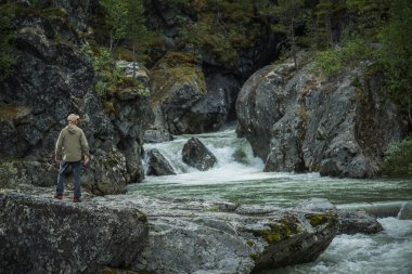 40 'lı yaşlarındaki Kafkas Turist Şelalesi ve Norveç' teki Rocky River Vadisi 'ni keşfediyor. Açık Hava Teması.