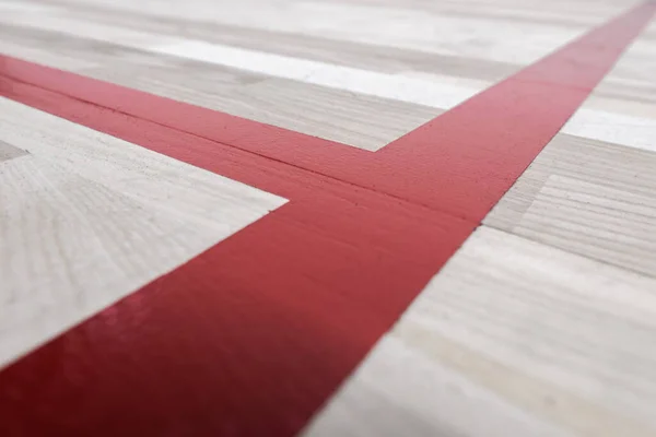 Wooden Sports Flooring With Painted Red Lines Close Up Photo.