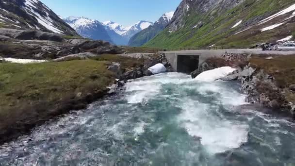 道路橋の下に流れる渓流と背景に流れる雪景色ノルウェーの風景 — ストック動画