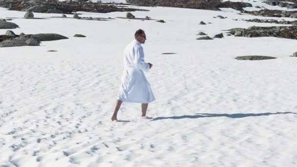 Hombre Viajero Albornoz Blanco Caminando Descalzo Nieve Tomando Café Mientras — Vídeo de stock