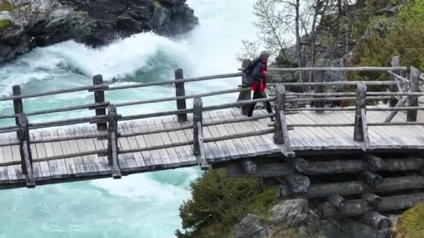 Veduta Aerea Escursionista Montagna Che Attraversa Ponte Legno Una Cascata — Video Stock