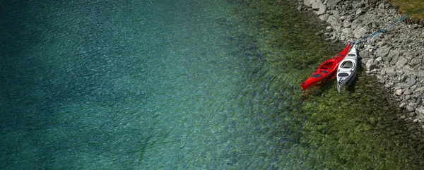 2つのカヤックの空中ビュークリスタルクリア水で山湖のロッキーショアにドッキングしました 野外活動テーマ — ストック写真