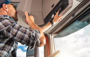 Profesyonel Kamyon Şoförü, bir konvoydaki diğerleriyle iletişim kurmak için telsiz kullanıyor.