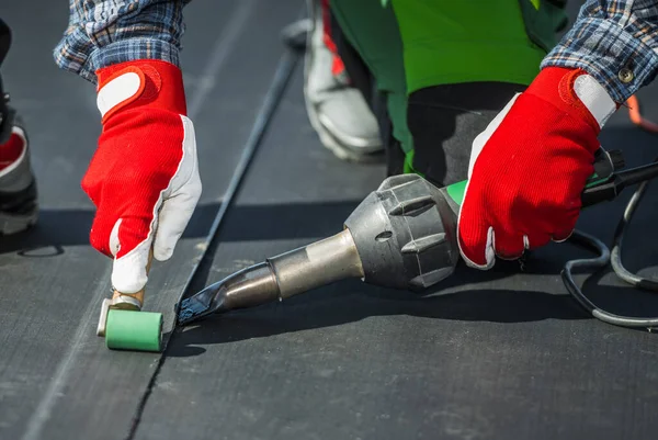 stock image Contractor Covering Building Roof with EPDM Vinyl Rubber Material Close Up Photo.