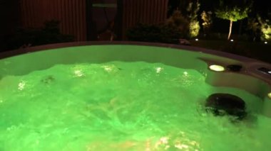 Green LED Underwater Lights tarafından aydınlatılan Modern Hit Küvet. Arka bahçede akşam.