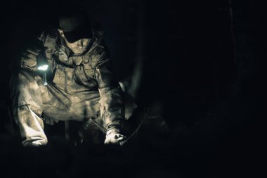 40 'lı yaşlarda beyaz bir adam gece yarısı kayıp kişi saatinde el feneriyle aranıyor.