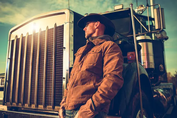 40多岁的白人半货车牛仔司机在他的车辆旁边欣赏日落美景 — 图库照片