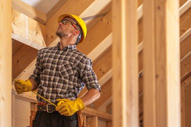 Elindeki mezura ile profesyonel inşaat müteahhidi. İnşaat Sitesi TemasıName.