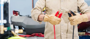 Elinde Otomobil Sıçrama Kablosu olan Profesyonel Araç Tamircisi