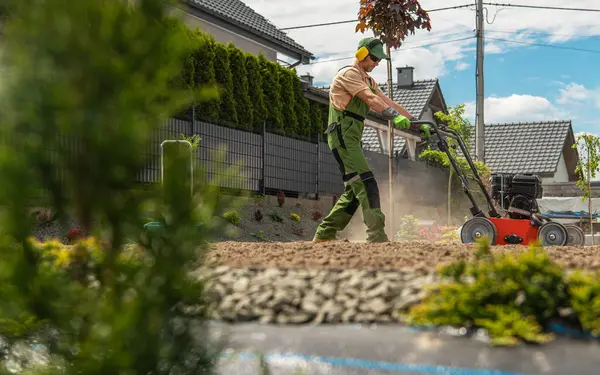 Moderne Landschaftspfleger Vorbereitung Hinterhof Boden Mit Einem Naturrasen Rasen Bedecken Stockfoto