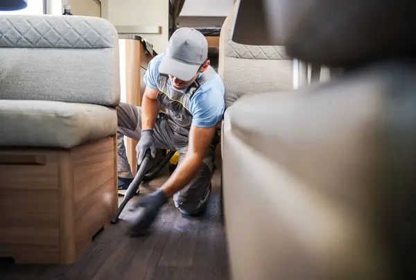 Caucasian Worker Vacuuming Cleaning Rental Motor Home Recreational Vehicle Maintenance Stock Photo