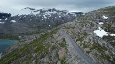 Tepelerin İçinden Geçen Virajlı Yol 'la Norveç' in Havadan Görünümü. Arkaplanda Karla Kaplanmış Dağlar.