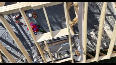 Çatı kirişinin hava görüntüsü ve Profesyonel Müteahhit, Güvenlik Ekipmanlarını Çalışmaya Başlatmak İçin Çalıştırıyor. İnşaat Endüstrisi Teması.