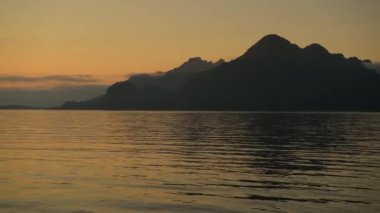 Sessiz Nehir 'in Huzurlu Manzarası ve Batan Güneş' in Işığındaki Yüksek Dağlar. Doğa Teması.